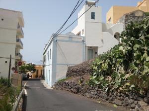 uma rua com um edifício branco e uma parede de pedra em Casa Emma em Valle Gran Rey