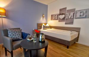 um quarto de hotel com uma cama, uma cadeira e uma mesa em Kempe Komfort plus Hotel em Solingen