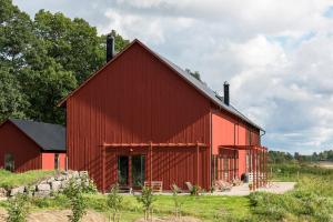 un fienile rosso seduto sopra un campo di Lindeborgs Eco Retreat a Vrena