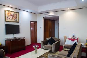 uma sala de estar com duas cadeiras e uma televisão em Lake View Resort Hotel em Mbarara