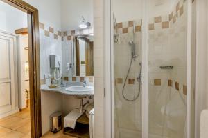 a bathroom with a shower, sink, and toilet at Hotel Costa Caddu in San Teodoro