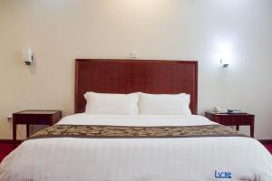 a hotel room with a large bed with a wooden headboard at Lake View Resort Hotel in Mbarara
