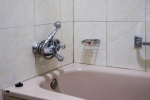 a bath tub with a faucet in a bathroom at Lake View Resort Hotel in Mbarara
