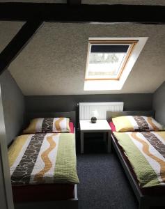 a small bedroom with two beds and a window at Penzion Fáfa in Rozvadov