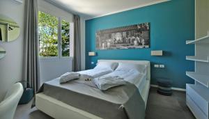 una camera con un letto con una parete blu di Relais Villa Clodia a Lazise