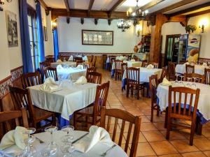 a restaurant with tables and chairs with white tablecloths at Hotel Rural Castúo H CC 656 in Pinofranqueado