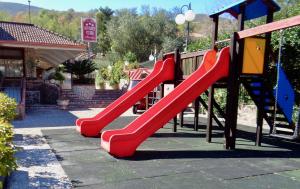 a playground with a red slide in a park at Hotel Ristorante Belvedere in Caserta