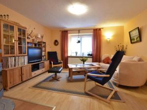 a living room with a couch and a chair and a table at Pretty Apartment in Am Salzhaff with Fireplace in Rakow