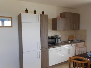a kitchen with a white refrigerator and a table at Spacious Apartment with Garden near Sea in Kropelin in Kröpelin