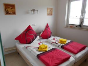 a bedroom with two beds with red and yellow towels at Spacious Apartment with Garden near Sea in Kropelin in Kröpelin
