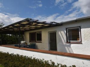 a pergola on the side of a house at Peaceful Bungalow in Diedrichshagen near Baltic Sea in Diedrichshagen