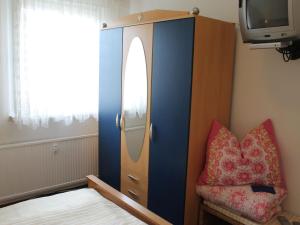 a bedroom with a blue door and a chair and a tv at Cozy Apartment in Walkendorf with Garden in Walkendorf