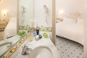 a bathroom with a sink and a mirror at Hotel Continental Ischia in Ischia