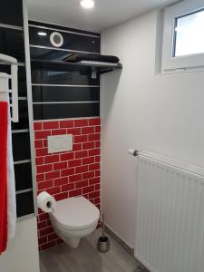 a bathroom with a toilet and a brick wall at Joli Studio in Metz