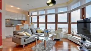a living room with a couch and a tv at Dom & House - Apartamenty Sea Towers in Gdynia