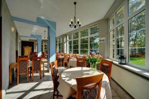 un comedor con mesas, sillas y ventanas en Hotel Belweder - przy hotelu Golebiewski, en Karpacz
