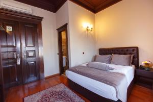 - une chambre avec un grand lit et une porte dans l'établissement Tahir Aga Konagi Hotel, à Trabzon