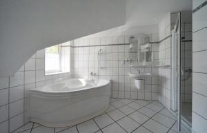 Baño blanco con bañera y lavamanos en Hotel Belweder - przy hotelu Golebiewski, en Karpacz