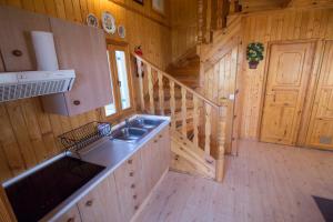 a kitchen with a sink and a staircase in a cabin at El Paso de las Cigüeñas in Candeleda