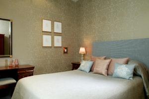 a bedroom with a large bed and a large mirror at Tufton Arms Hotel in Appleby