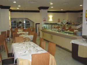 un restaurant avec des tables et des chaises blanches et un comptoir dans l'établissement Don Juan, à Grenade