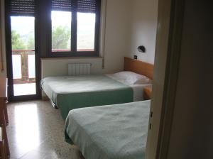 a room with three beds and two windows at MillePini in Calatafimi