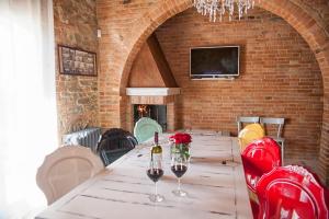 una sala da pranzo con tavolo e 2 bicchieri di vino di Villa Ventotto a Marciano Della Chiana
