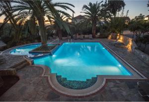 a swimming pool in a backyard with a palm tree at Maria Suites in Plataniás