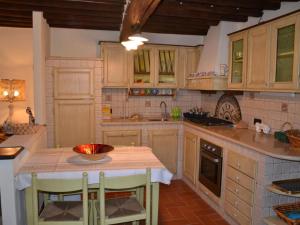 une cuisine avec des placards en bois et une table avec des chaises dans l'établissement Fabulous Holiday Home in Capannori with Pool, à Castelvecchio