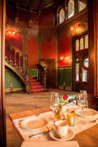 uma sala de jantar com uma mesa e uma escada em Pension VILLA KLEINE WARTBURG em Eisenach