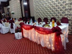a table set up for a banquet with red and white bows at Hotel Rebis in Brăila