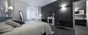 - une chambre noire et blanche avec un lit et une chaise dans l'établissement Suite Vogue Visconti, à Voghera