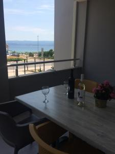 a table with two glasses and a bottle of wine at Apartments Ante in Omiš