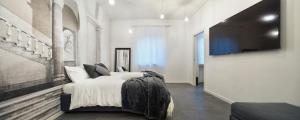a bedroom with a bed and a flat screen tv at Suite Vogue Sforza in Voghera