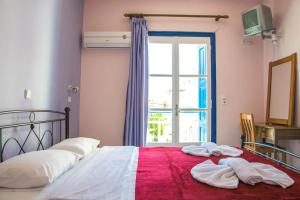 ein Schlafzimmer mit einem Bett mit Handtüchern darauf in der Unterkunft Hotel Mariona in Pythagoreio