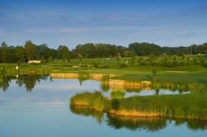 a golf course with a lake in the foreground at DAS LUDWIG Sports Resort in Bad Griesbach