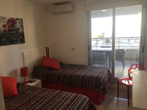 a hotel room with two beds and a balcony at Apartamento Forest 2 in Punta del Este +28 photos