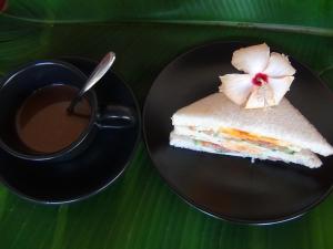 a piece of cake on a plate next to a cup of coffee at Tuaprodhome in Khao Lak
