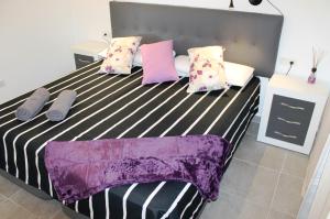 1 dormitorio con cama blanca y negra con almohadas en Las Arecas Villa, en Yaiza 10 fotos más
