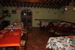 a dining room with tables and chairs with red tablecloths at La Casanuova in Lajatico