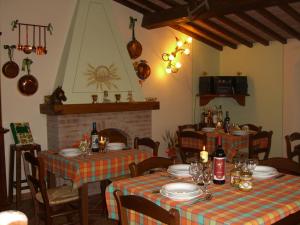 a dining room with two tables and a fireplace at La Casanuova in Lajatico