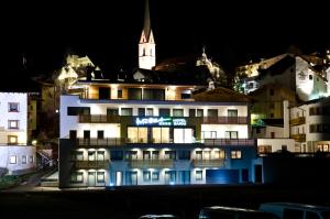 un edificio alberghiero con una torre dell'orologio sullo sfondo di Hotel Garni Arosa a Ischgl