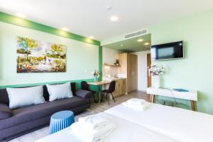 a hotel room with two beds and a couch at Menta City Boutique Hotel in Rethymno Town