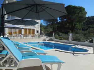 a pool with chairs and an umbrella and a swimming pool at White House Lopud in Lopud Island