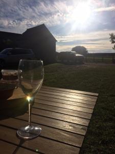 a glass of white wine sitting on a wooden table at Church Farm in Gillingham