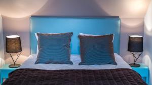 - une chambre bleue avec un lit et deux lampes dans l'établissement Cottage "Les GALETS" face au Lac de la forêt d'Orient - Les Cottages du Belvédère, à Mesnil-Saint-Père