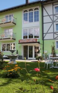 ein Hotelgebäude mit einem Brunnen im Hof in der Unterkunft Hotel Garni Regina in Gößweinstein