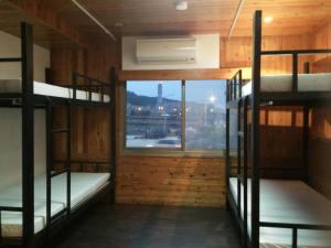 a room with three bunk beds and a window at Yes, Sir Homestay in Nangan
