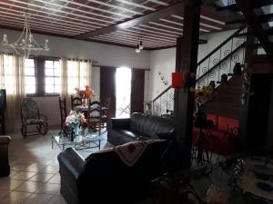 a living room with a couch and a table at Pousada Casa D` Guio in Rio das Ostras