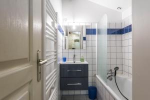 y baño con lavabo y espejo. en Château Croix Beauséjour "Maison du Vigneron" en Montagne